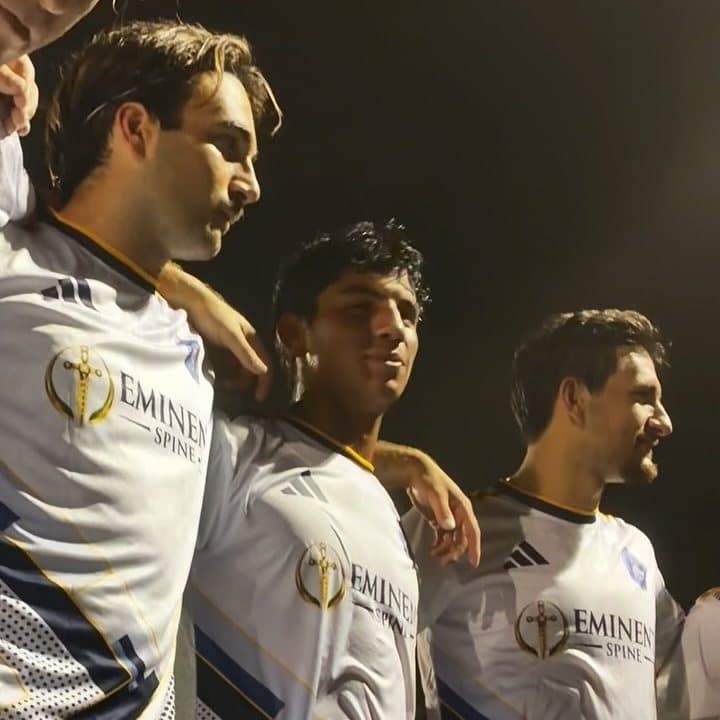 Jugadores de Dade County FC abrazados bajo las luces del estadio